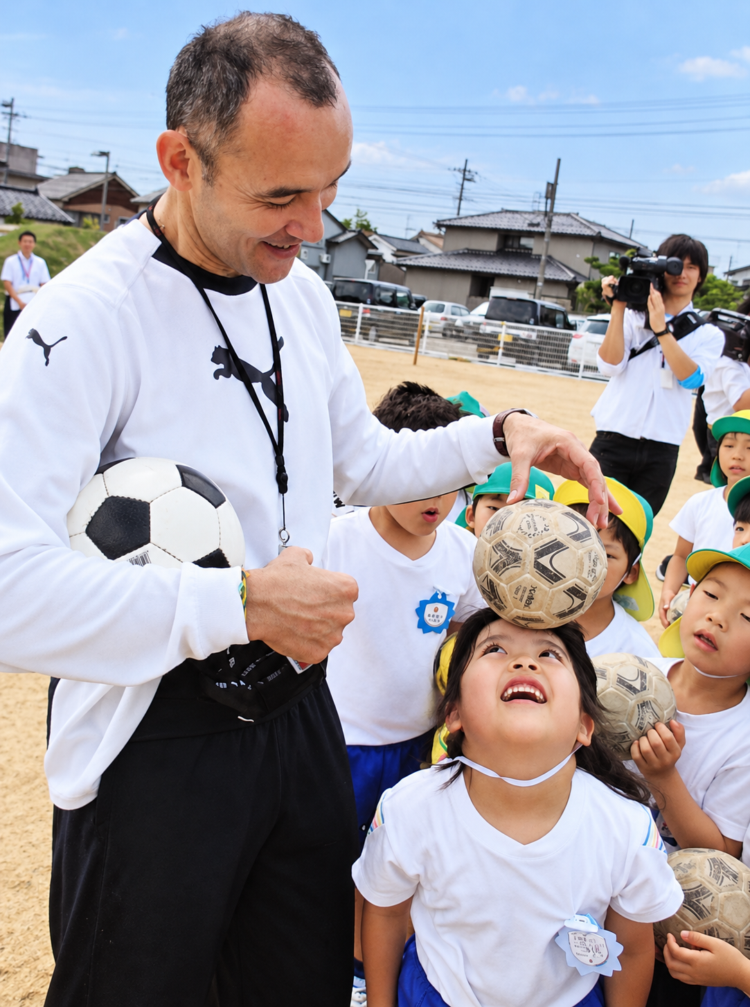 ボールを頭に載せて子どもたちと笑顔を見せる宮澤ミシェル