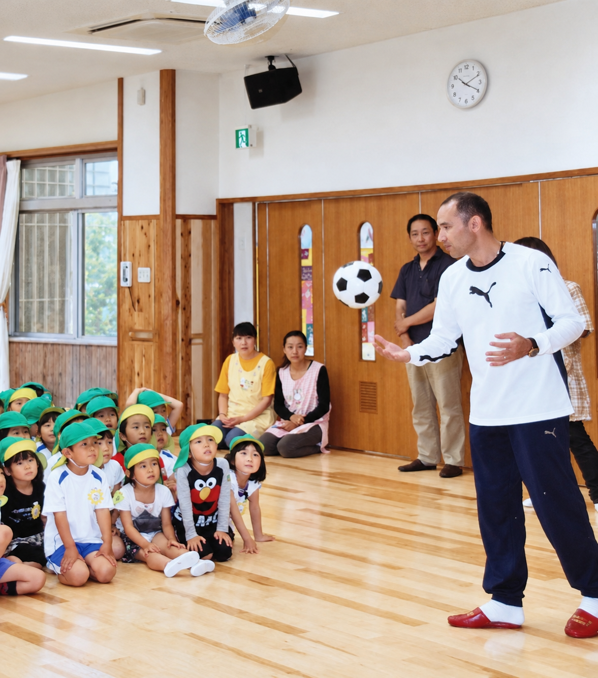 体育館で子どもたちにサッカーボールを使って見せる宮澤ミシェル